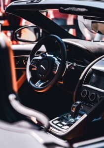 Interior of a luxury car with sleek dashboard, steering wheel, console, and modern design.