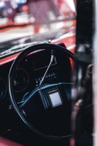 Chevrolet vehicle interior showing black steering wheel and dashboard with red accents.